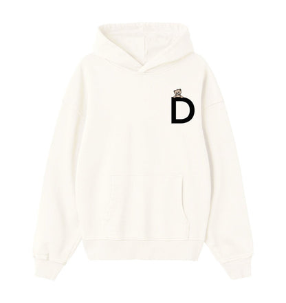 Oversized hoodie in creme voor heren en dames van DESONS, met een minimalistisch wit logo en teddybeeraccent op de borst. Luxe streetwear hoodie.