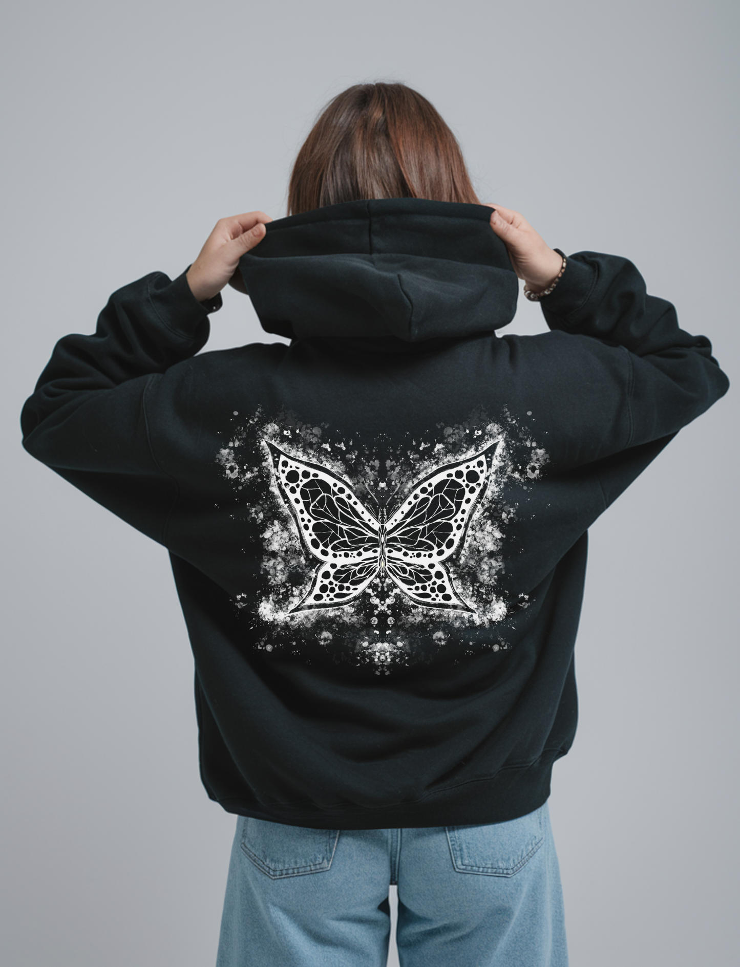 Oversized zwarte hoodie voor heren en dames van DESONS, met een opvallende abstracte vlinderprint in wit op de achterkant. Luxe streetwear hoodie.